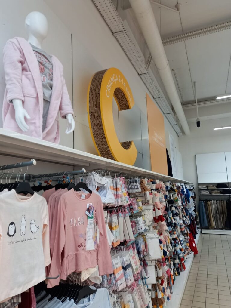 Letra caixa "C" de grande formato em placa estruturada — sinalização de seção infantil